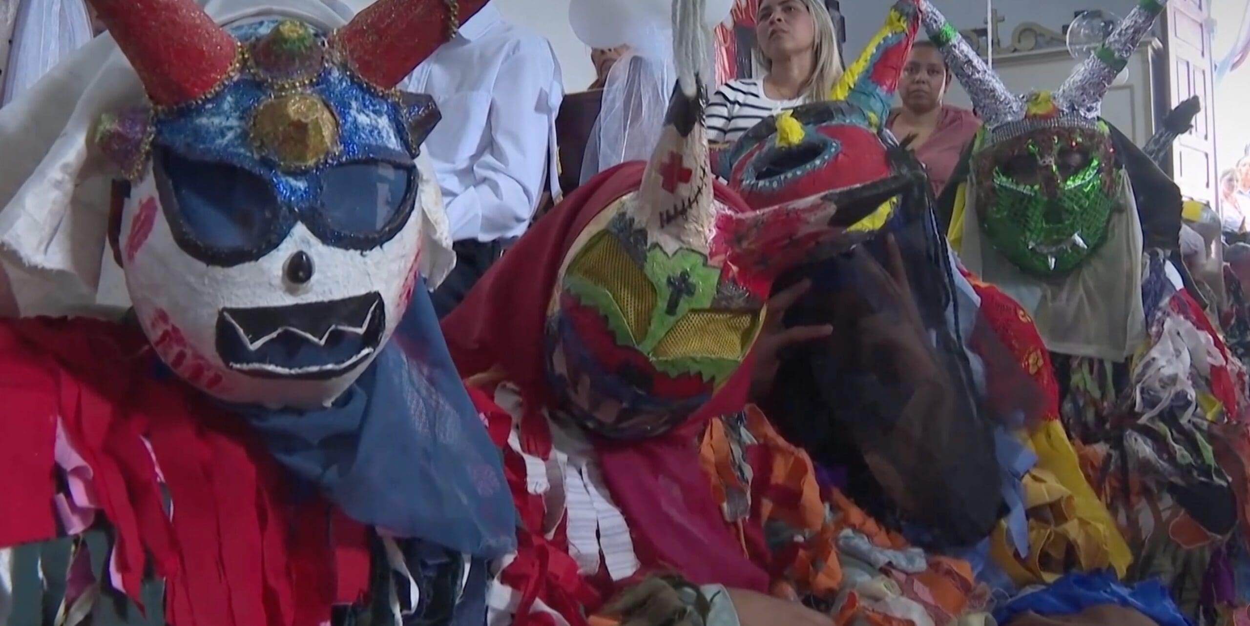 À Tarmas, au Venezuela, des enfants célébrant leur première communion défilent aux côtés des célèbres « Diables danseurs », des personnages masqués traditionnellement. Photo : Capture d'écran d' Euronews.